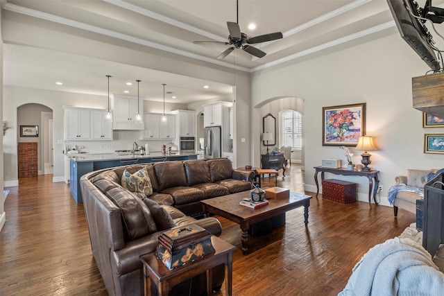 living room featuring recessed lighting, arched walkways, a ceiling fan, and ornamental molding