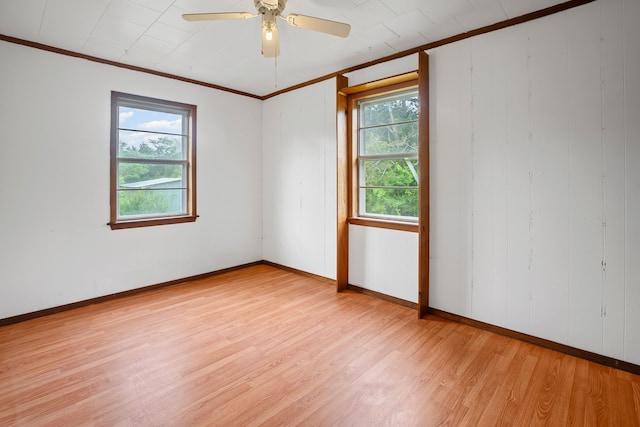 unfurnished room with baseboards, ornamental molding, ceiling fan, and light wood-type flooring