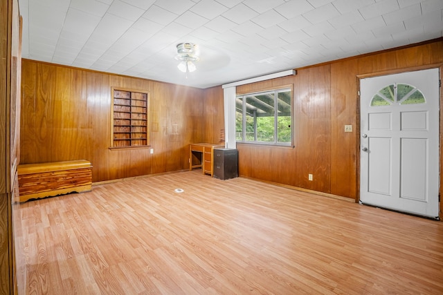 foyer entrance featuring ceiling fan, wood walls, and wood finished floors
