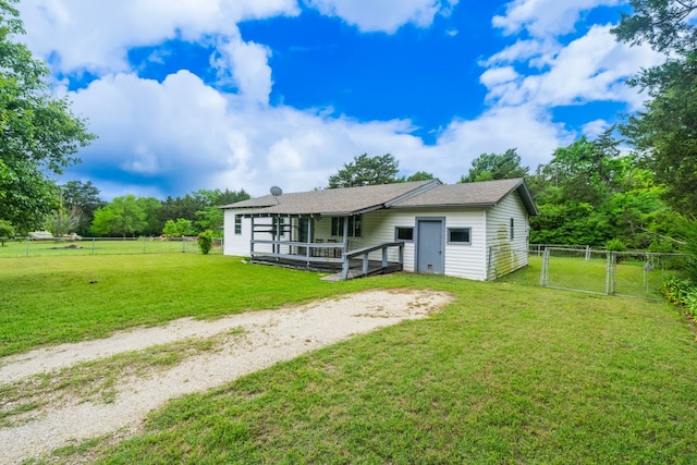 rear view of house featuring a fenced backyard, a gate, and a lawn