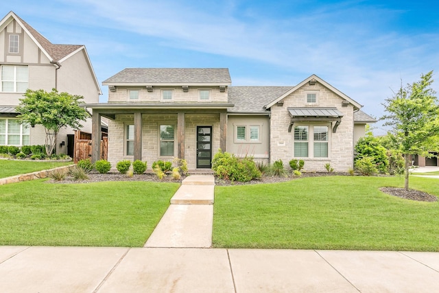 craftsman-style home with a shingled roof, a front lawn, and stone siding