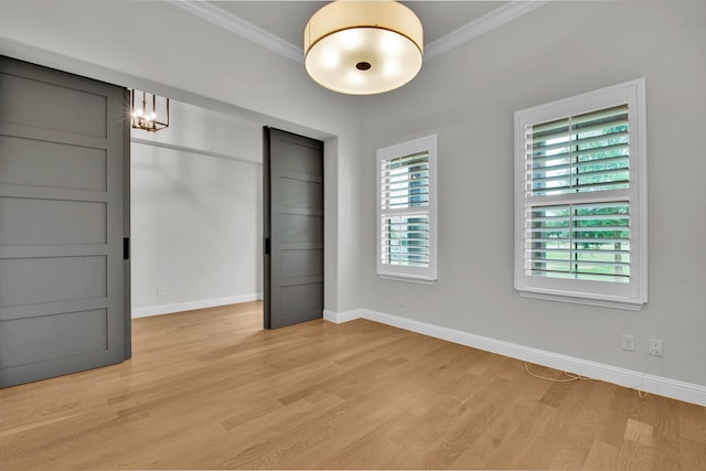unfurnished room with baseboards, ornamental molding, and light wood-style floors