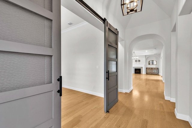 entryway featuring light wood-style floors, baseboards, an inviting chandelier, and a fireplace