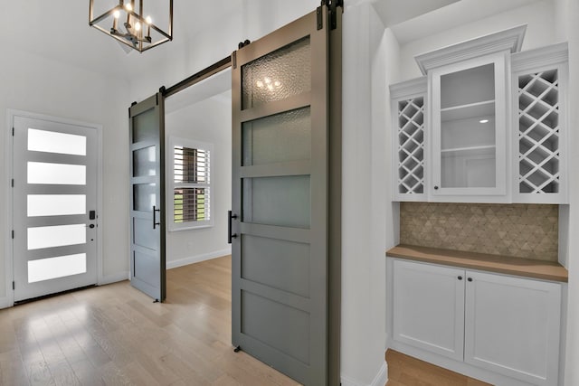 1844 Quiet Oak Pl, Fort Worth, TX 76008 - entrance foyer featuring a barn door, light wood-style floors, and a chandelier