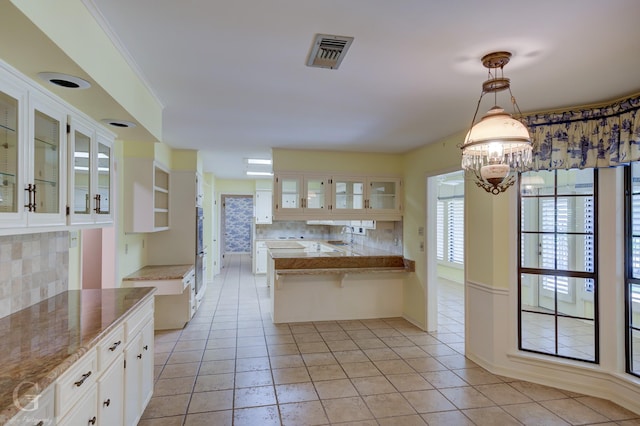5030 Old Mooringsport Rd, Shreveport, LA 71107 - kitchen with a peninsula, visible vents, glass insert cabinets, and tasteful backsplash