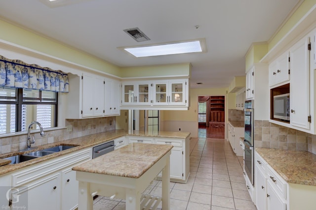 5030 Old Mooringsport Rd, Shreveport, LA 71107 - kitchen featuring a sink, stainless steel appliances, a peninsula, light tile patterned floors, and visible vents
