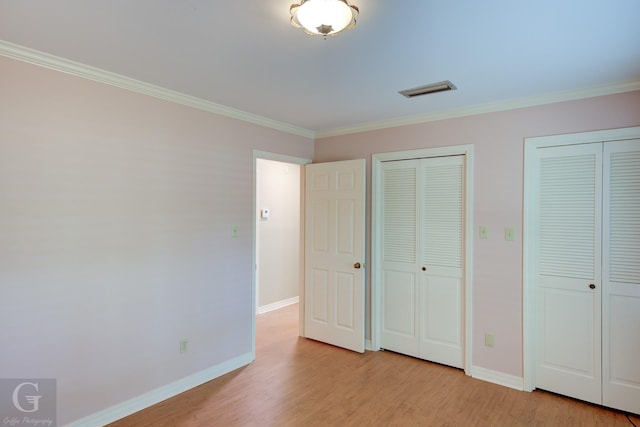 5030 Old Mooringsport Rd, Shreveport, LA 71107 - unfurnished bedroom with crown molding, baseboards, two closets, and wood finished floors