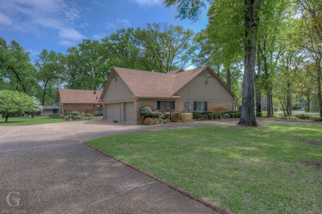 5030 Old Mooringsport Rd, Shreveport, LA 71107 - view of front of home with a front yard, brick siding, a shingled roof, an attached garage, and driveway