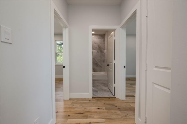 hallway with baseboards and wood finished floors