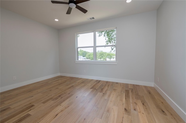 empty room with visible vents, light wood finished floors, ceiling fan, and baseboards