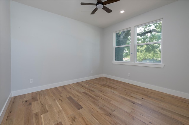 empty room featuring baseboards, light wood finished floors, and ceiling fan