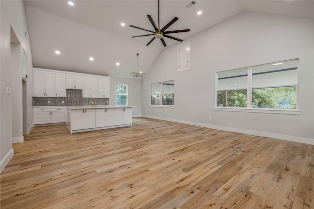 328 Whispering Trl, Gun Barrel City, TX 75156 - kitchen with open floor plan, high vaulted ceiling, white cabinetry, light countertops, and a kitchen island with sink