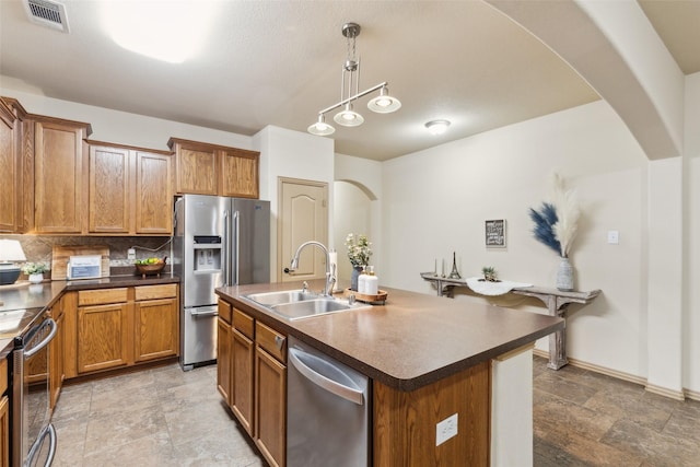 1925 Bridgeport Dr, Providence Village, TX 76227 - kitchen featuring visible vents, dark countertops, arched walkways, a sink, and appliances with stainless steel finishes