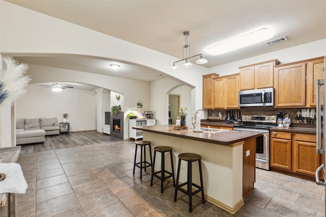 1925 Bridgeport Dr, Providence Village, TX 76227 - kitchen featuring visible vents, decorative backsplash, dark countertops, open floor plan, and appliances with stainless steel finishes