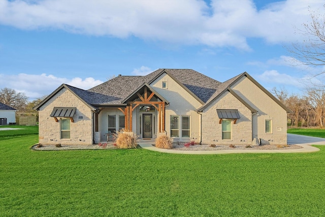 view of front facade featuring a front lawn, roof with shingles, and stone siding