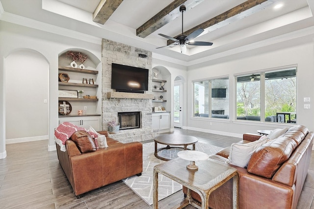 living room with arched walkways, baseboards, and wood finished floors