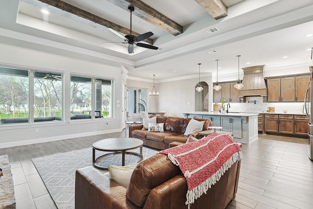 living room with baseboards, visible vents, beam ceiling, and ceiling fan with notable chandelier