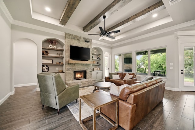 317 Wayward Spur, Springtown, TX 76082 - living area featuring arched walkways, a fireplace, a ceiling fan, dark wood-style floors, and beamed ceiling