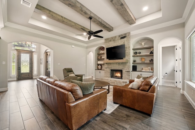 317 Wayward Spur, Springtown, TX 76082 - living room with arched walkways, plenty of natural light, a fireplace, beam ceiling, and baseboards