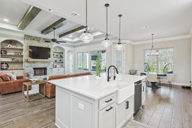 kitchen with wood finished floors, visible vents, a sink, and a fireplace