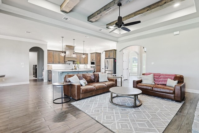 living room with arched walkways, ceiling fan, visible vents, and wood finished floors