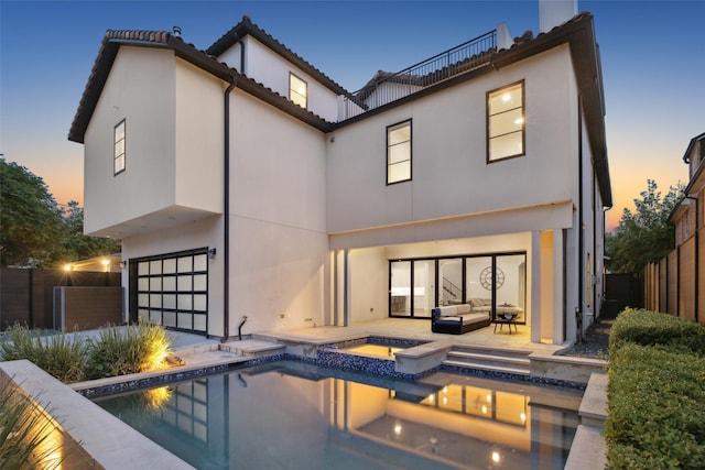 back of property with stucco siding, an outdoor living space, a fenced in pool, an attached garage, and an in ground hot tub