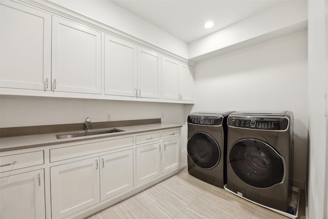 laundry room with recessed lighting, a sink, cabinet space, and washer and dryer