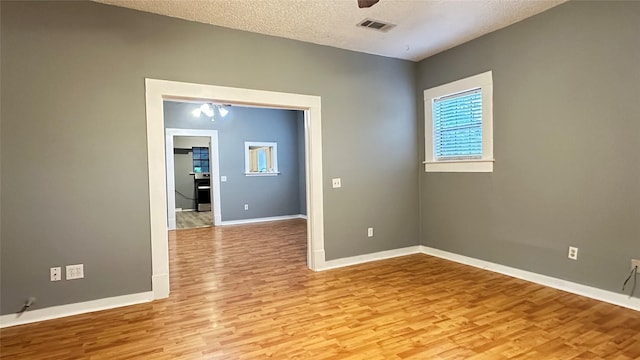 empty room featuring visible vents, baseboards, ceiling fan, and light wood-type flooring