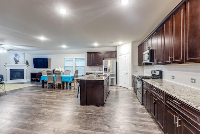 439 Tommie Lillian Ln, Celina, TX 75009 - kitchen with a kitchen bar, wood finished floors, open floor plan, and appliances with stainless steel finishes