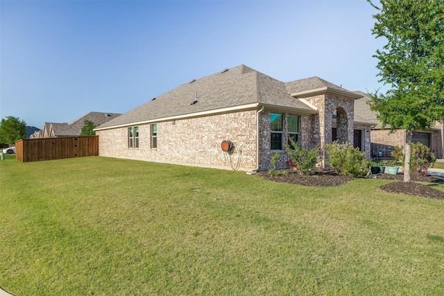 439 Tommie Lillian Ln, Celina, TX 75009 - back of property with an attached garage, fence, a shingled roof, a yard, and brick siding