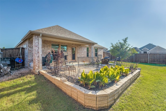439 Tommie Lillian Ln, Celina, TX 75009 - back of property with roof with shingles, brick siding, a patio, a fenced backyard, and a lawn