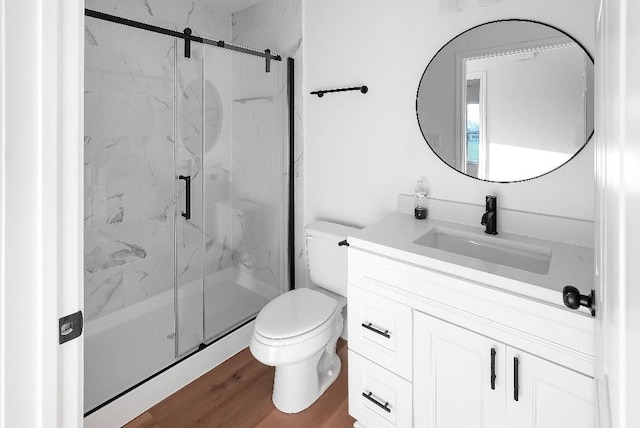 full bathroom with vanity, a marble finish shower, wood finished floors, and toilet