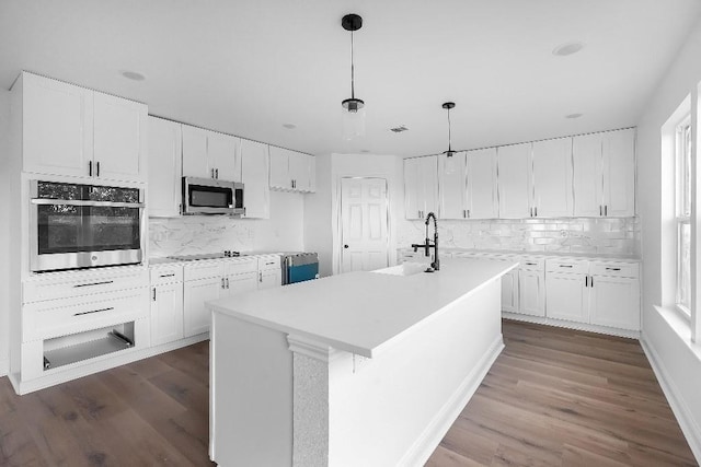 kitchen featuring dark wood-style flooring, white cabinetry, appliances with stainless steel finishes, and tasteful backsplash