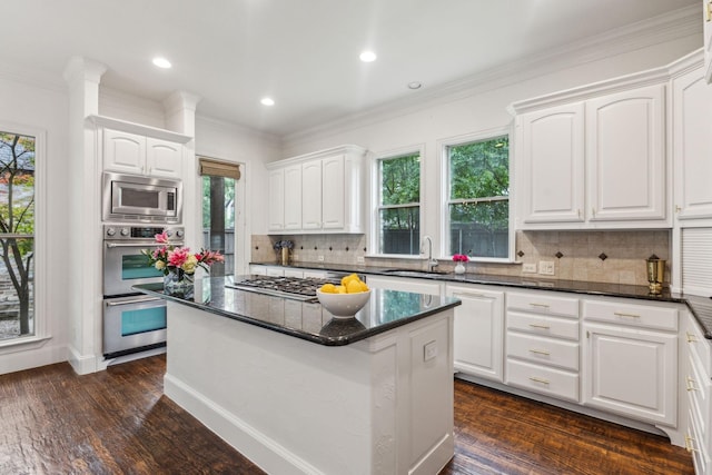 kitchen with a sink, white cabinetry, backsplash, and stainless steel appliances