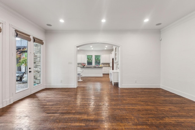 unfurnished living room with dark wood-type flooring, arched walkways, recessed lighting, and ornamental molding