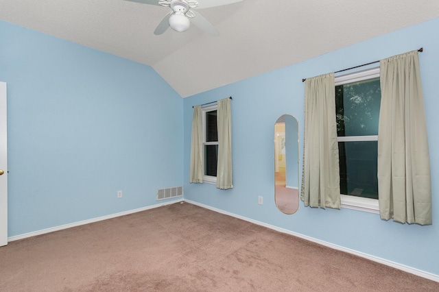 7208 Stoddard Ln, Plano, TX 75025 - carpeted empty room featuring visible vents, baseboards, ceiling fan, arched walkways, and vaulted ceiling