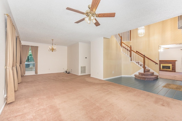 7208 Stoddard Ln, Plano, TX 75025 - unfurnished living room featuring visible vents, stairway, carpet floors, ceiling fan with notable chandelier, and a glass covered fireplace