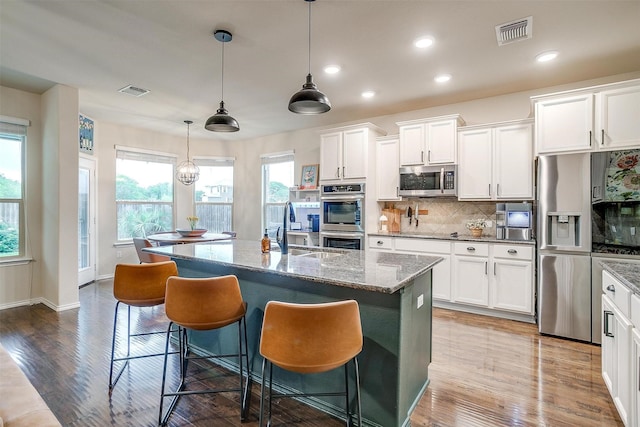 kitchen with visible vents, decorative backsplash, a wealth of natural light, and stainless steel appliances