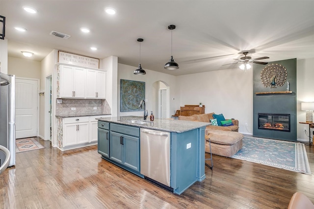 kitchen with visible vents, arched walkways, dishwasher, a sink, and white cabinets