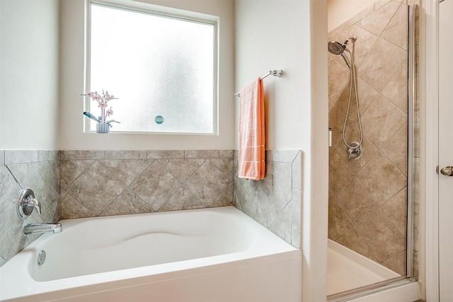 bathroom with a healthy amount of sunlight, a stall shower, and a bath