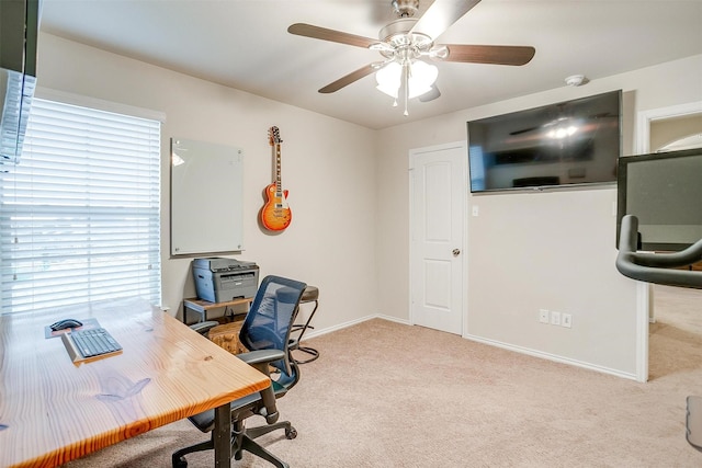 carpeted home office with baseboards and a ceiling fan