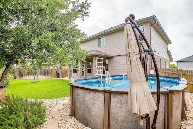 view of pool featuring a fenced in pool, fence, and a lawn