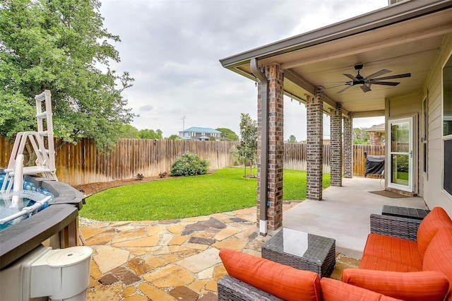 view of patio / terrace featuring a hot tub, a ceiling fan, and a fenced backyard