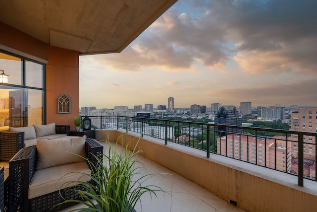 balcony at dusk with a view of city and an outdoor hangout area