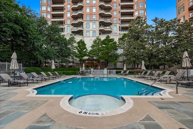 community pool with a patio and fence