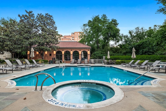 community pool with a hot tub and a patio