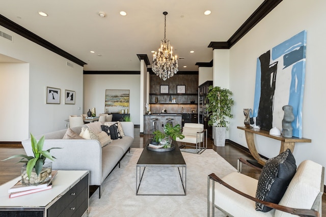 living room with recessed lighting, a notable chandelier, ornamental molding, and light wood-type flooring