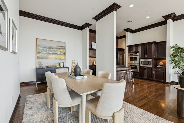 dining room featuring visible vents, ornamental molding, dark wood-style flooring, and baseboards
