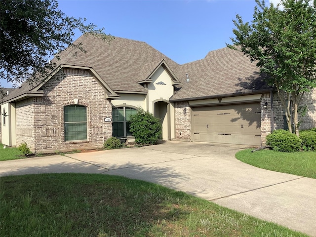 701 Fox Den, Haughton, LA 71037 - french country home with driveway, a shingled roof, brick siding, and a garage