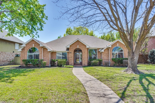 single story home with brick siding, a front lawn, roof with shingles, and fence